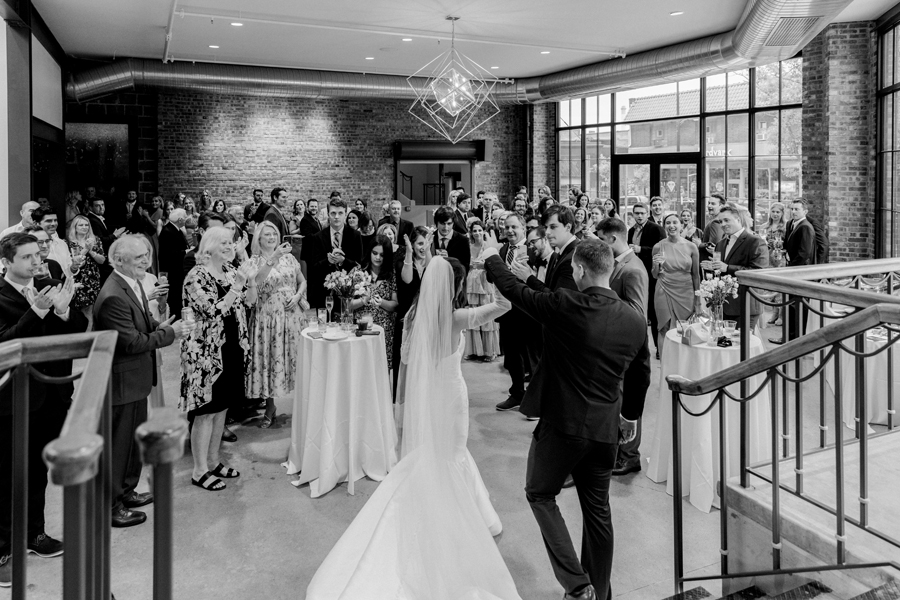The bride and groom walk to their reception at The Atrium on Tenth wedding in Columbia, Missouri by Love Tree Studios.