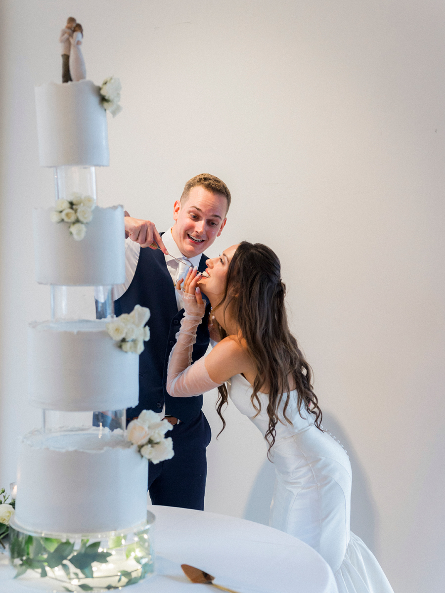 The bride and groom cut the cake during their reception for their The Atrium on Tenth wedding in Columbia, Missouri by Love Tree Studios.