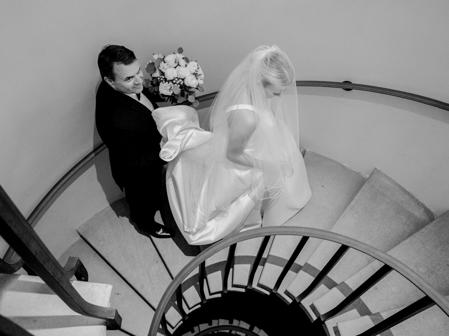 The bride and her father share a moment in the circular stairwell at a Westminster College wedding by Love Tree Studios.