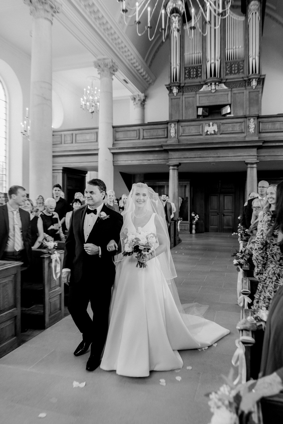 The bride and her father walk down the aisle in the Church of St. Mary, Aldermanbury at a Westminster College wedding by Love Tree Studios.