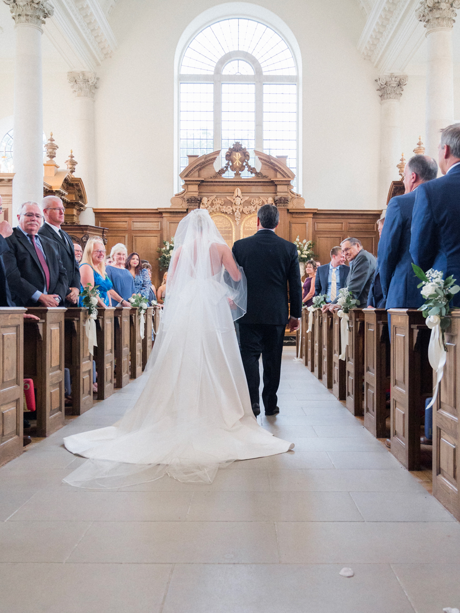 The bride and her father walk down the aisle in the Church of St. Mary, Aldermanbury at a Westminster College wedding by Love Tree Studios.
