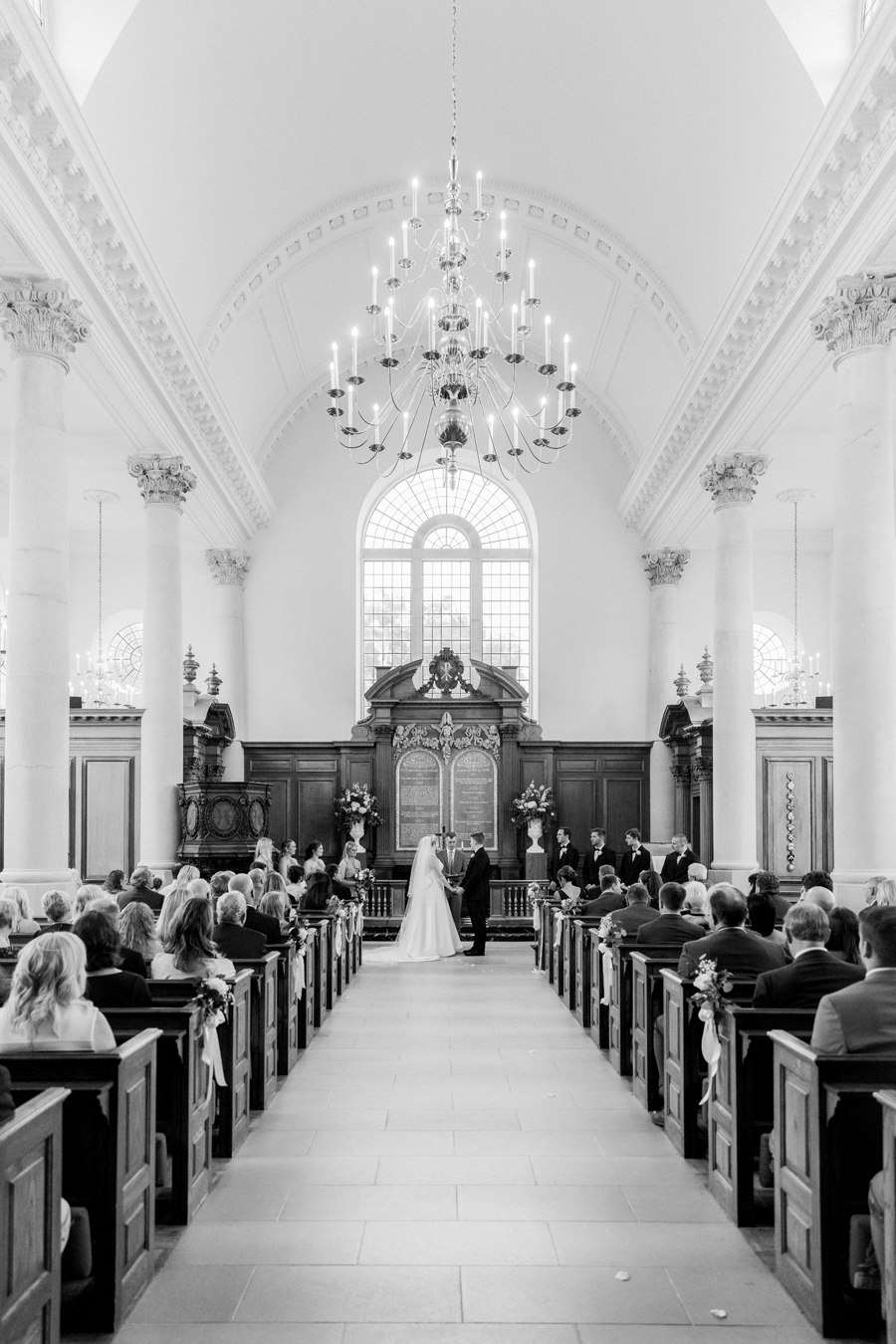 A bride and groom marry at the altar in the Church of St. Mary, Aldermanbury at a Westminster College wedding by Love Tree Studios.