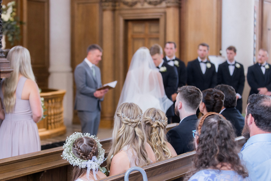 A bride and groom marry at the altar in the Church of St. Mary, Aldermanbury at a Westminster College wedding by Love Tree Studios.