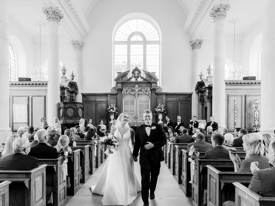 A bride walk down the aisle in the Church of St. Mary, Aldermanbury at a Westminster College wedding by Love Tree Studios.