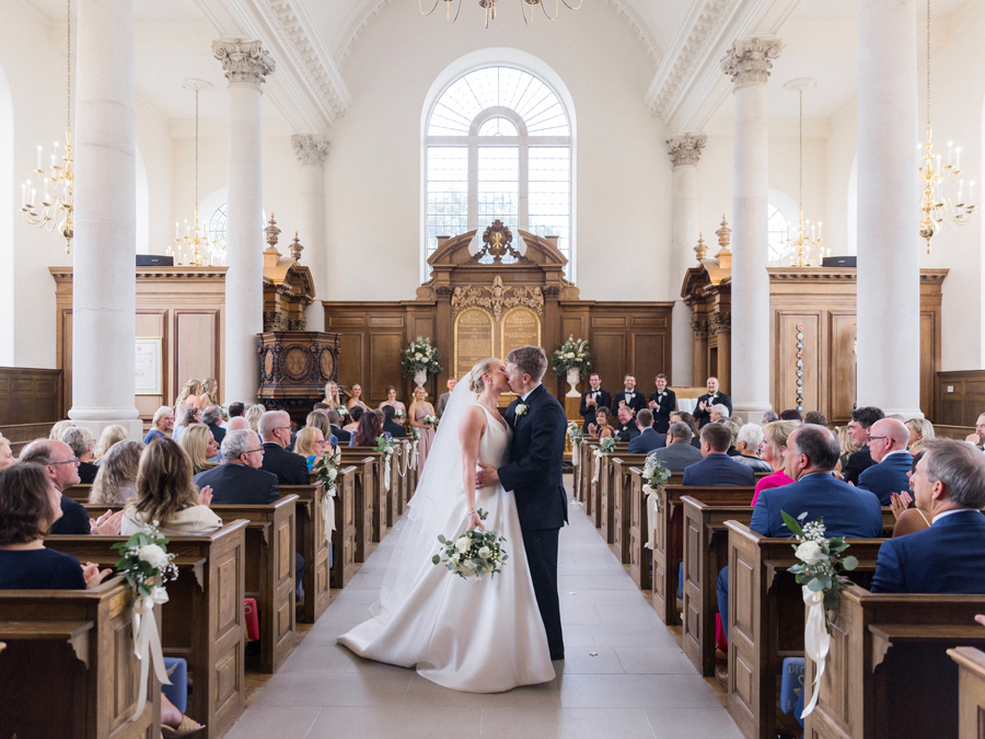 A bride walk down the aisle in the Church of St. Mary, Aldermanbury at a Westminster College wedding by Love Tree Studios.