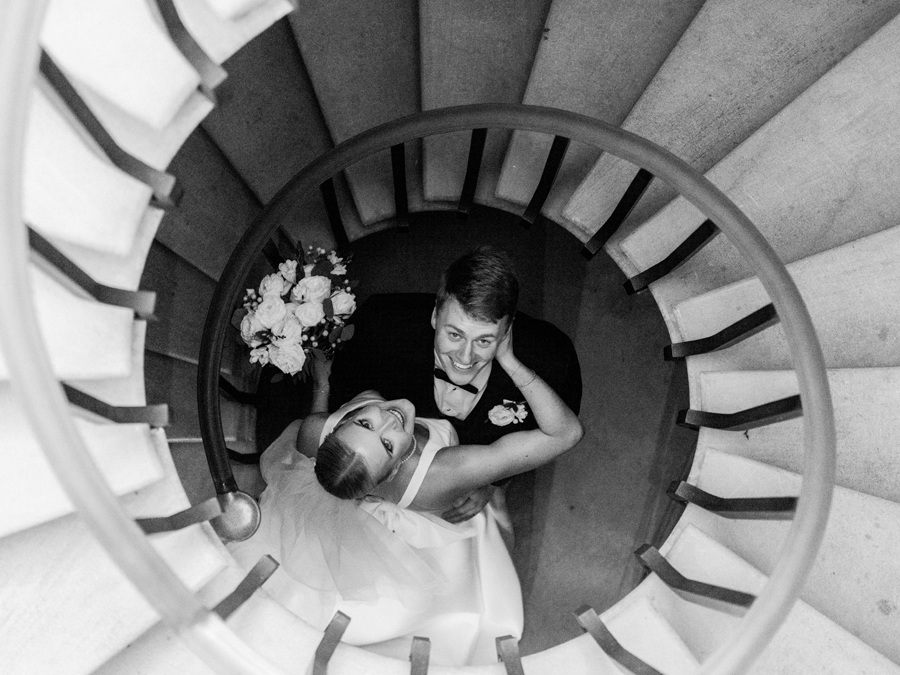 The bride and groom pose for portraits in the circular staircase at the Church of St. Mary, Aldermanbury at a Westminster College wedding by Love Tree Studios.