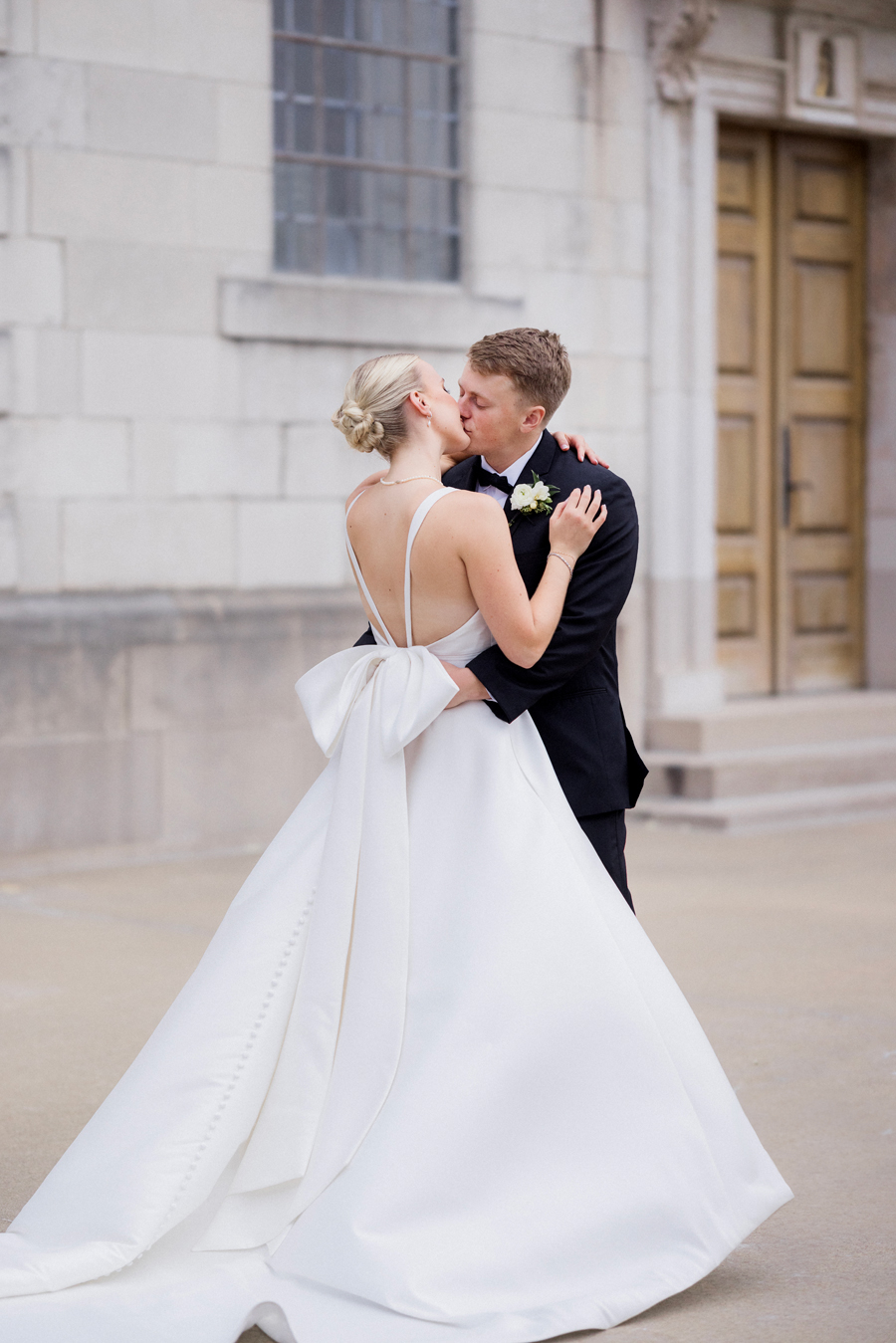 A bride and groom take portrait outside the Church of St. Mary, Aldermanbury at a Westminster College wedding by Love Tree Studios.
