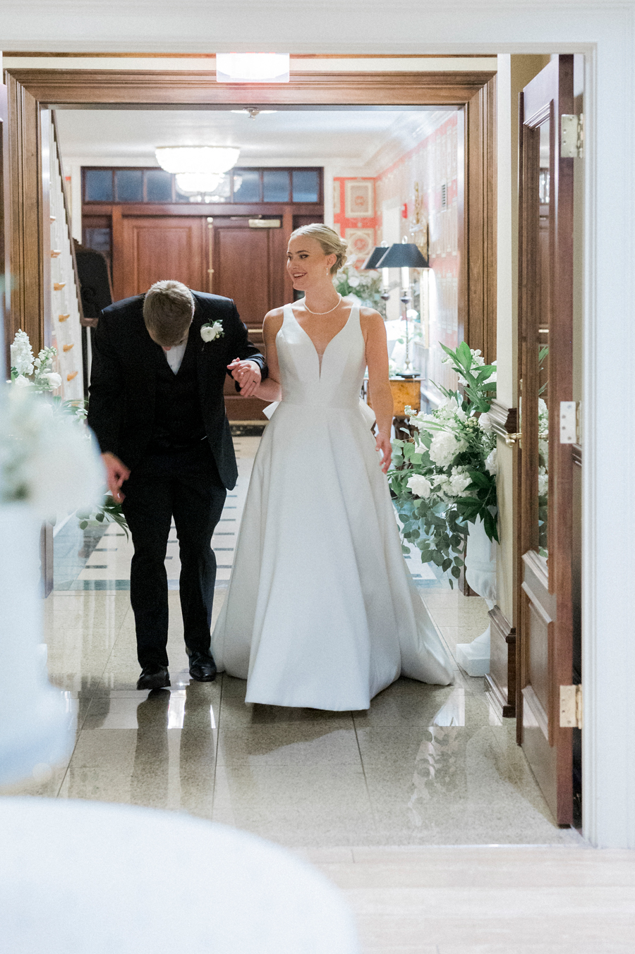 A bride and groom enter their reception at the Club at Old Hawthorne for a Westminster College wedding by Love Tree Studios.