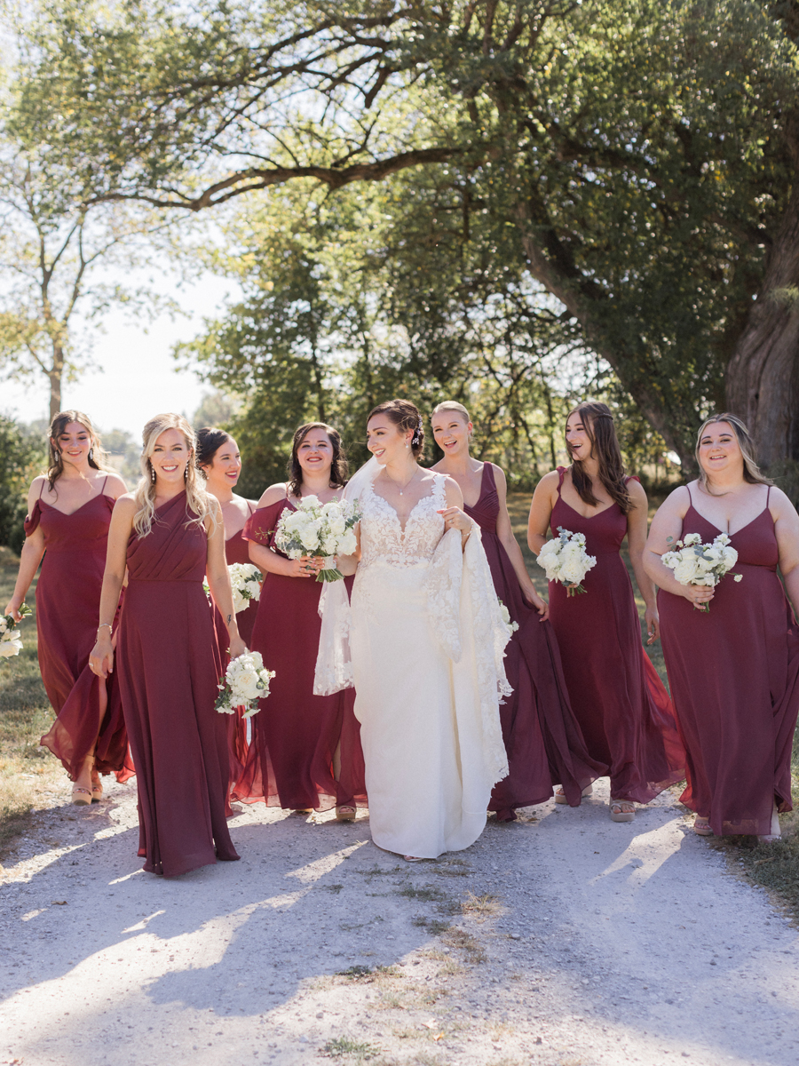 A bride poses with her bridesmaids for her Blue Bell Farm wedding by Missouri wedding photographer Love Tree Studios.