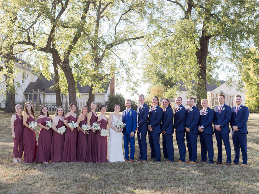 The wedding party takes photos at a Blue Bell Farm wedding by Missouri wedding photographer Love Tree Studios.