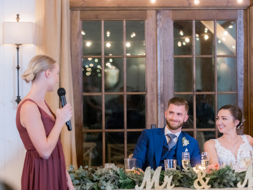 The bride and groom enter their wedding reception and listen to toasts at their Blue Bell Farm wedding by Missouri wedding photographer Love Tree Studios.