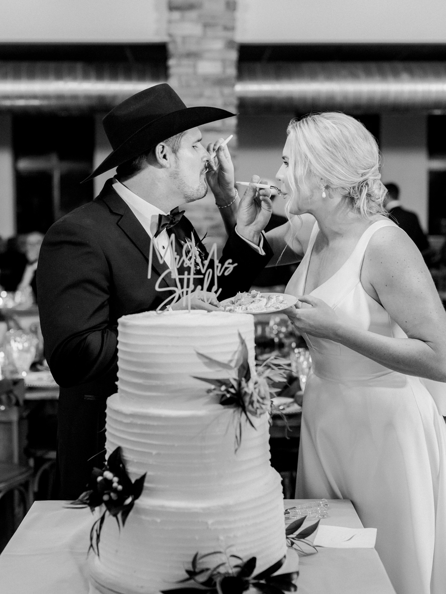 A bride and groom enter Capital Bluffs and cut the cake during their Jefferson City wedding photographed by Love Tree Studios.