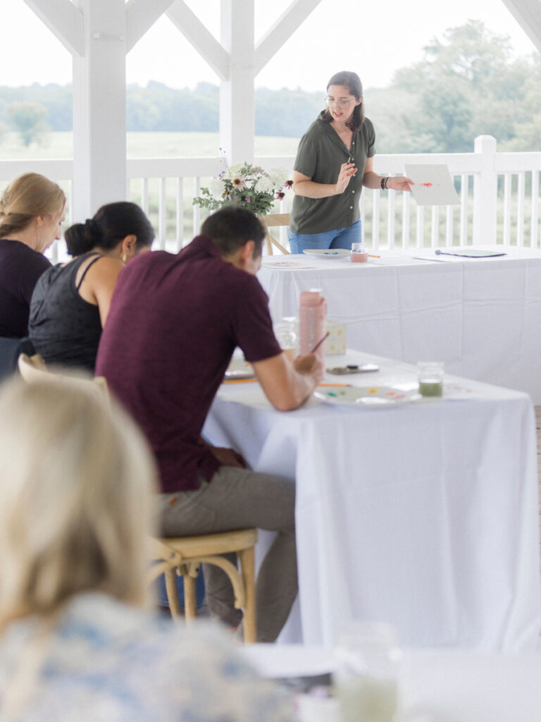 St. Louis artist Caitlin Allen instructing attendees on watercolor techniques at the Blue Bell Farm paint and picnic event.