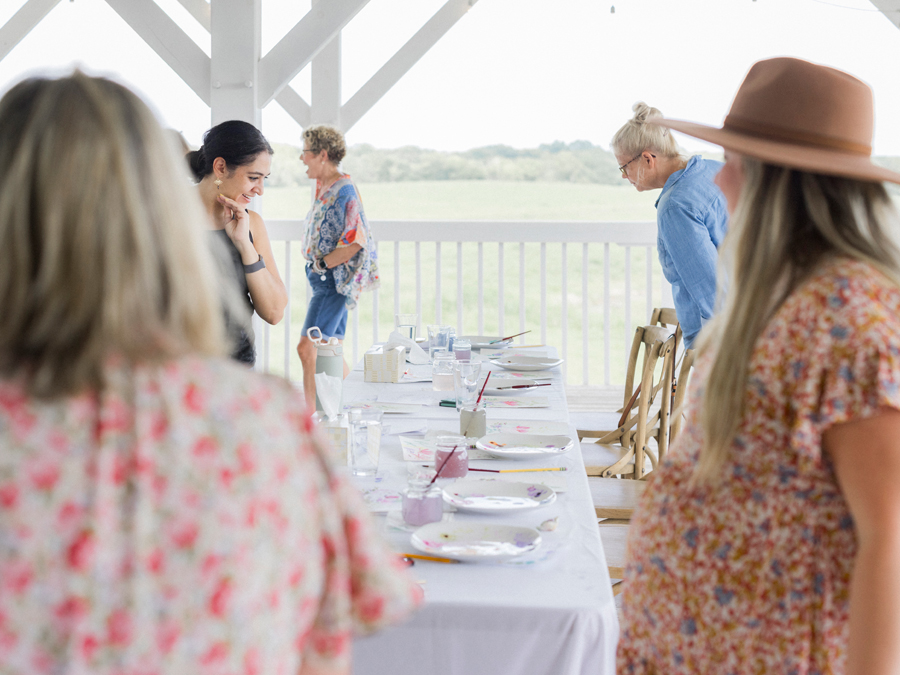 Attendees pose for a group photo with their watercolor painting under the guidance of Caitlin Allen Studios during the paint and picnic event.