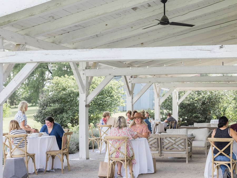 Attendees enjoying their picnic lunch from Beet Box, with the scenic Blue Bell Farm landscape in the background.