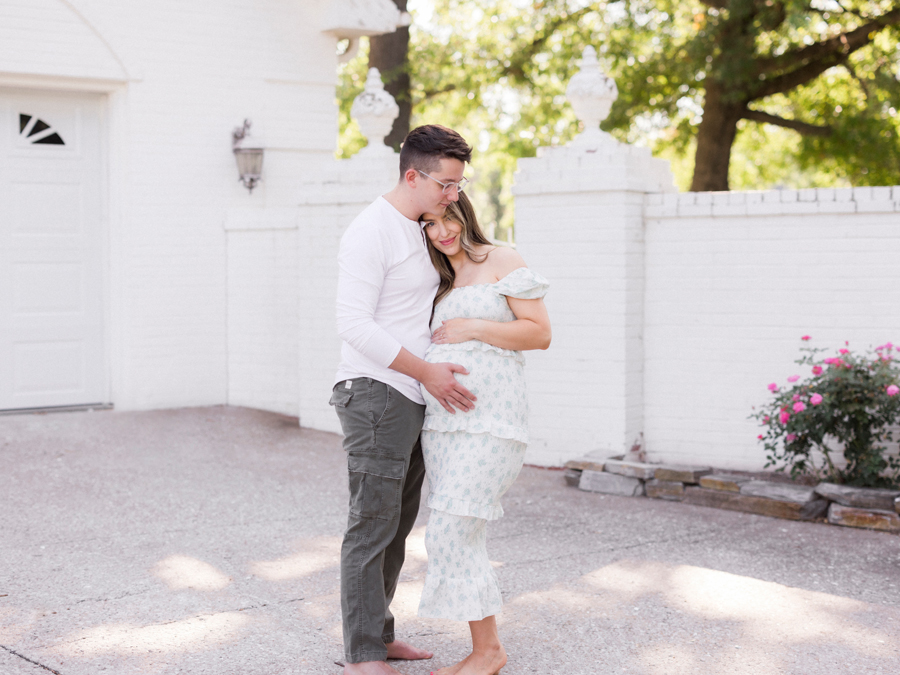 Mother-to-be standing gracefully in a garden, holding her belly during a family maternity session in Columbia, Missouri by Love Tree Studios.