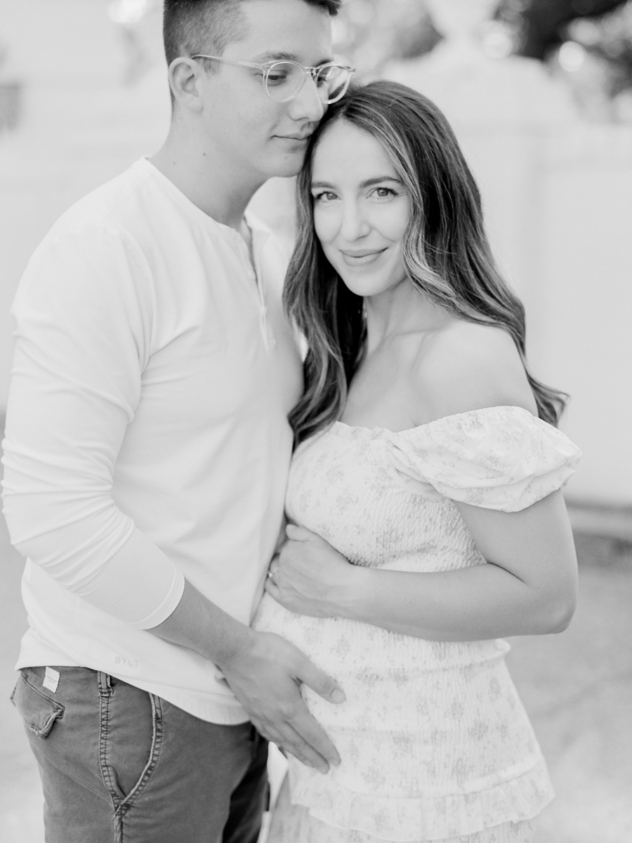 Mom and dad embracing with joy during their family maternity session in the outdoor Garden Studio by Love Tree Studios in Columbia, Missouri.