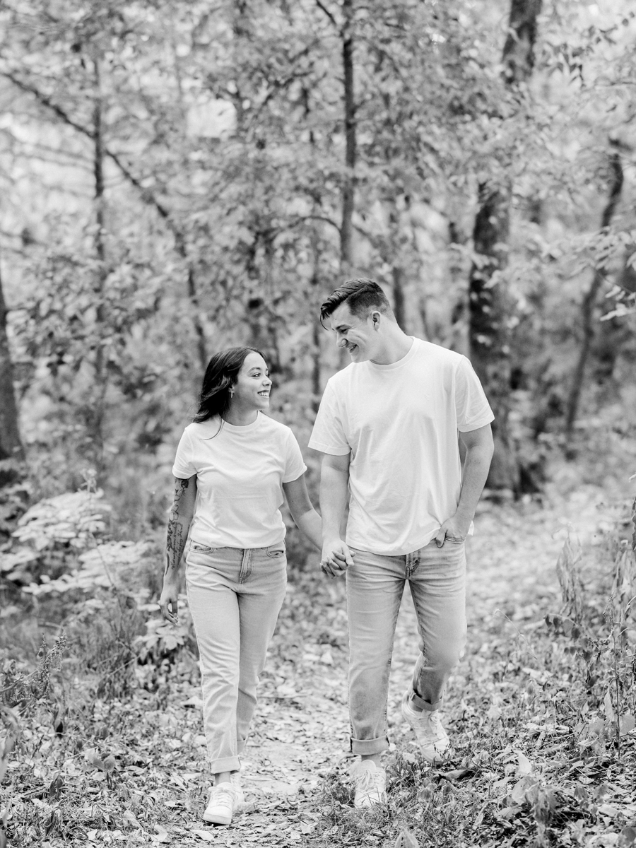 Bryanna and Chase holding hands in the woods during their Missouri engagement session.