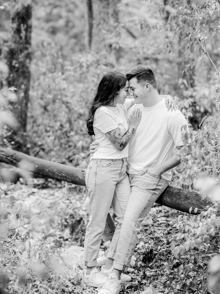 Candid moment of Bryanna and Chase laughing in the woods.