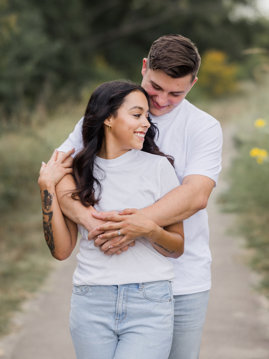 Engaged couple embracing in the Missouri countryside.