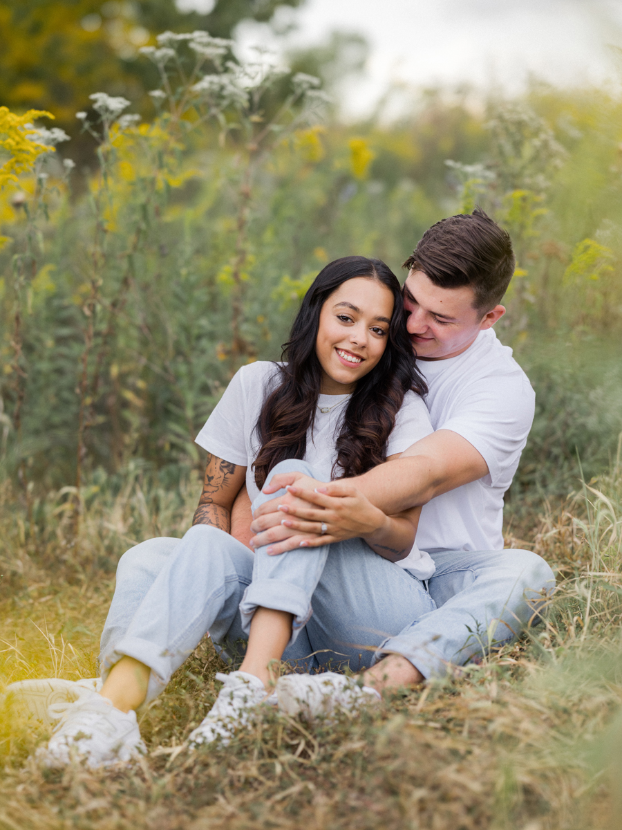 Couple laughing together in a field during their Missouri engagement session.