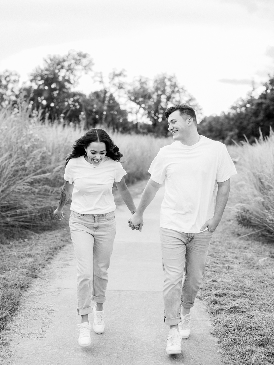 Couple walking toward the camera with trees in the background.