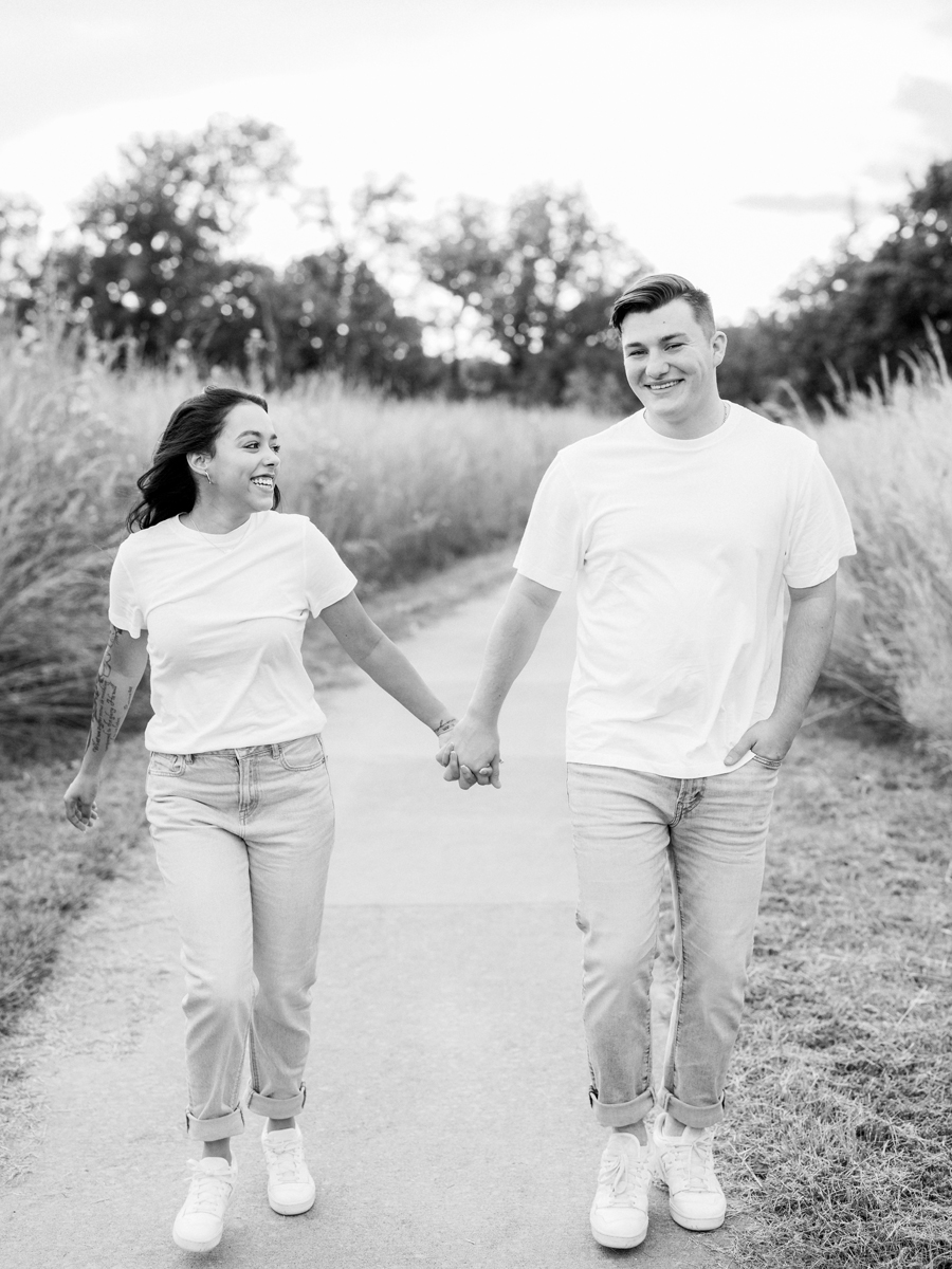 Bryanna and Chase walking side by side through a field in Columbia, Missouri.