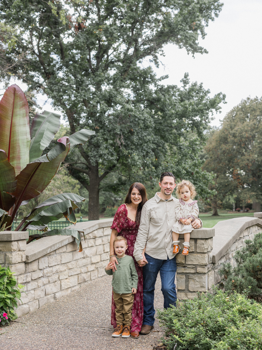 The Bahner family sitting together on a bridge at Shelter Gardens.