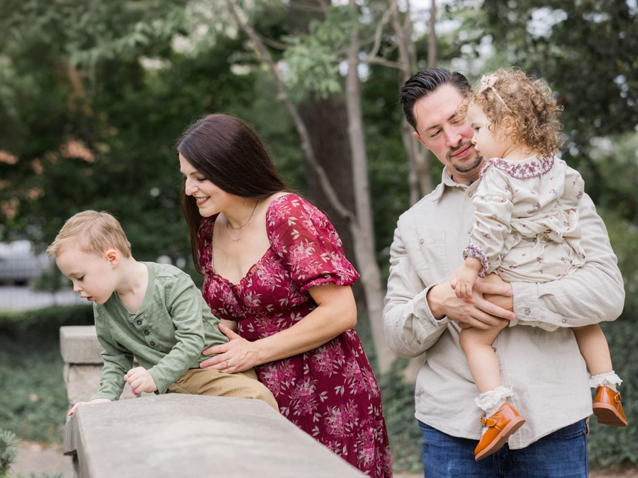 The Bahner family sitting on a bridge, enjoying a relaxed moment together.