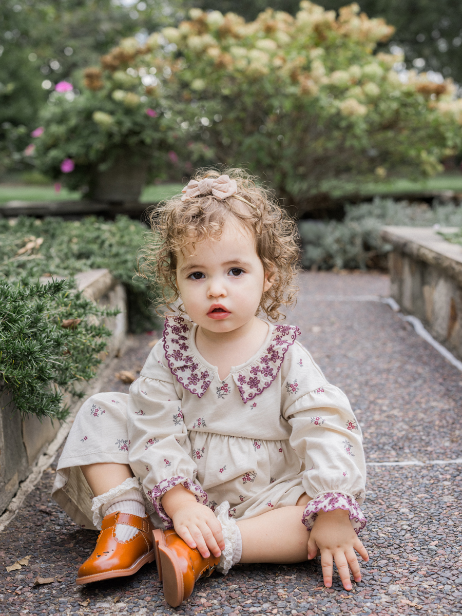 Mariah sitting on a park path, showcasing her shy personality.