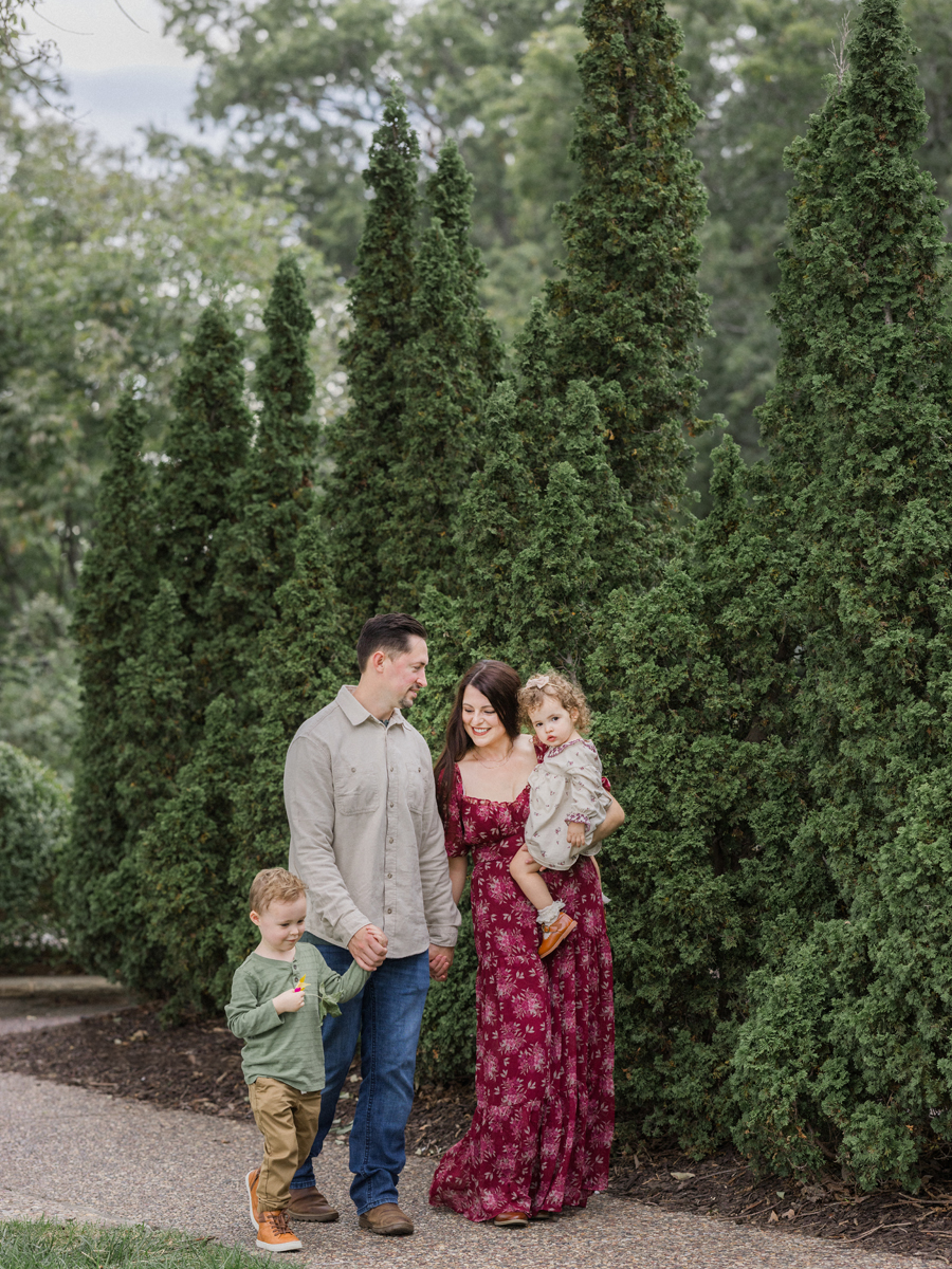 The Bahner family walking down a path, looking at each other and smiling.