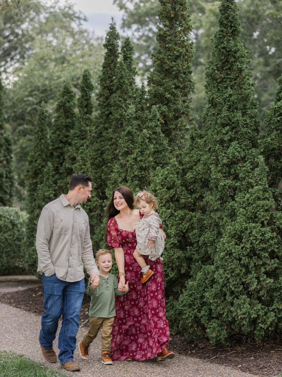 Rachel and Zach holding hands with Macklin and Mariah as they walk through a park.