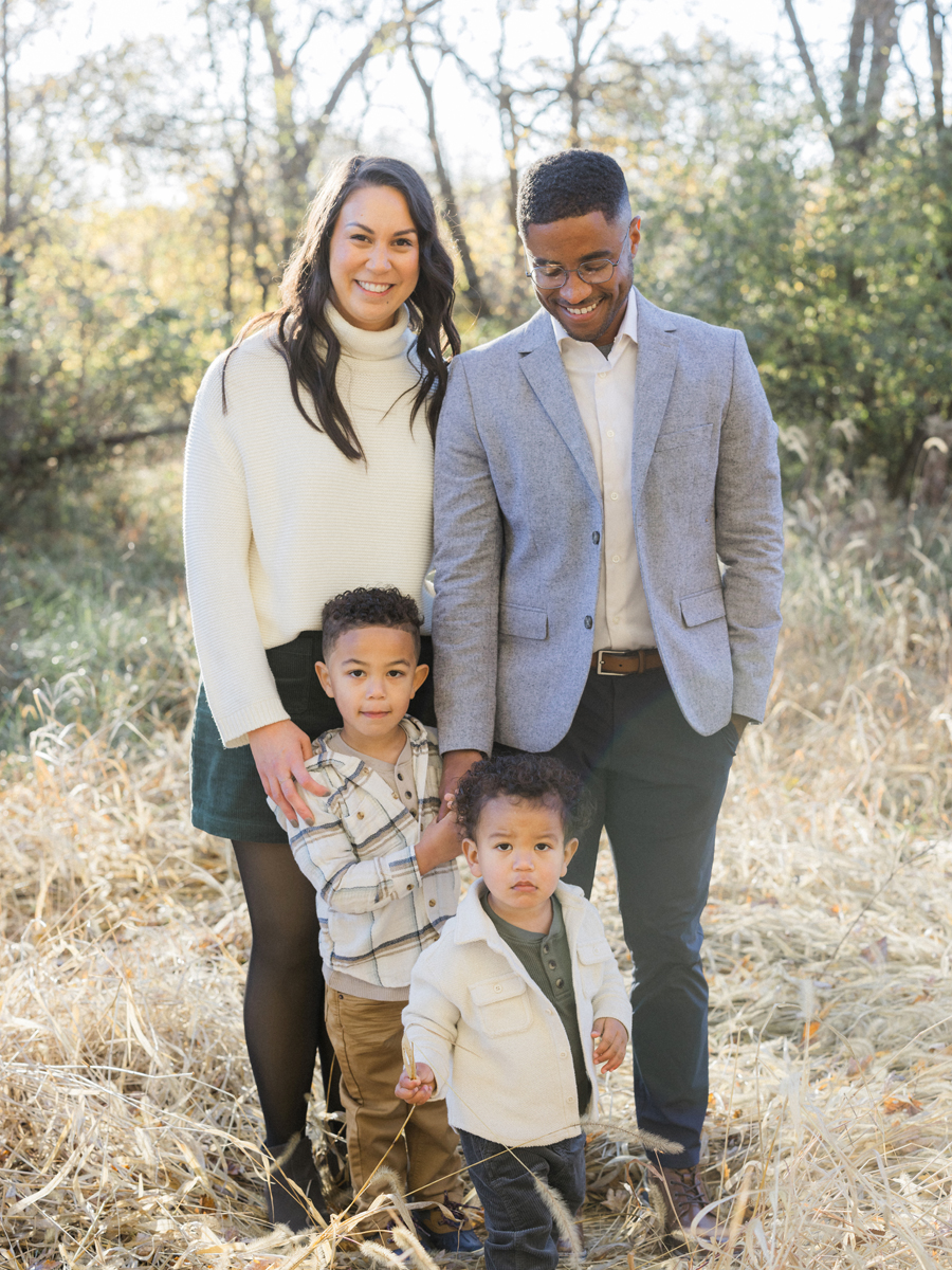 The Washington family standing in a field surrounded by fall colors at Pierpont Farms Family Session, captured by Love Tree Studios.