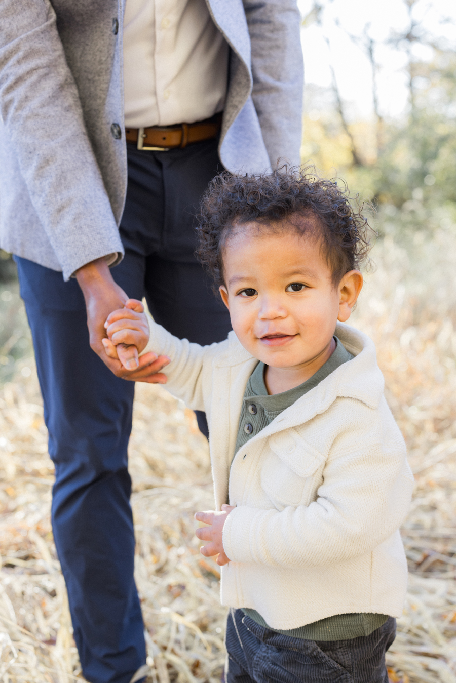 Little Theo smiling brightly in the fall leaves at Pierpont Farms Family Session, captured by Love Tree Studios.