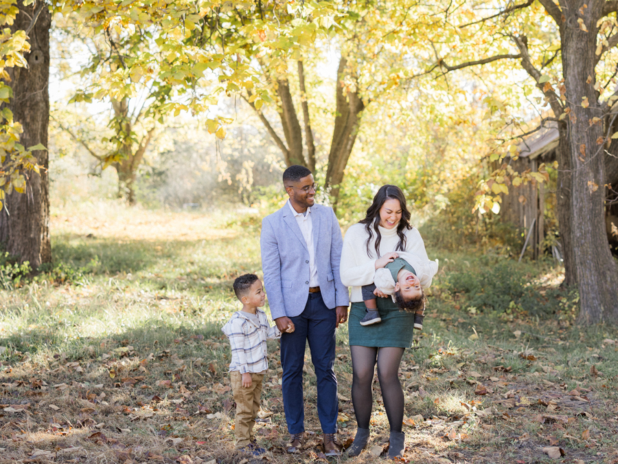 Portrait of the Washington family with fall trees in the background at Pierpont Farms Family Session, captured by Love Tree Studios.