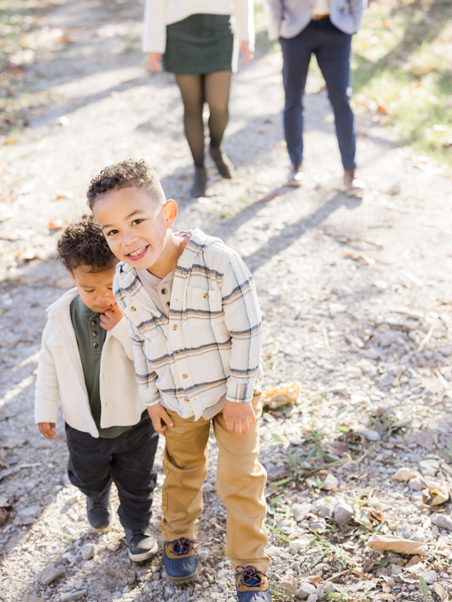 Myles and Theo playing together on the gravel path during their Pierpont Farms Family Session, photographed by Love Tree Studios.