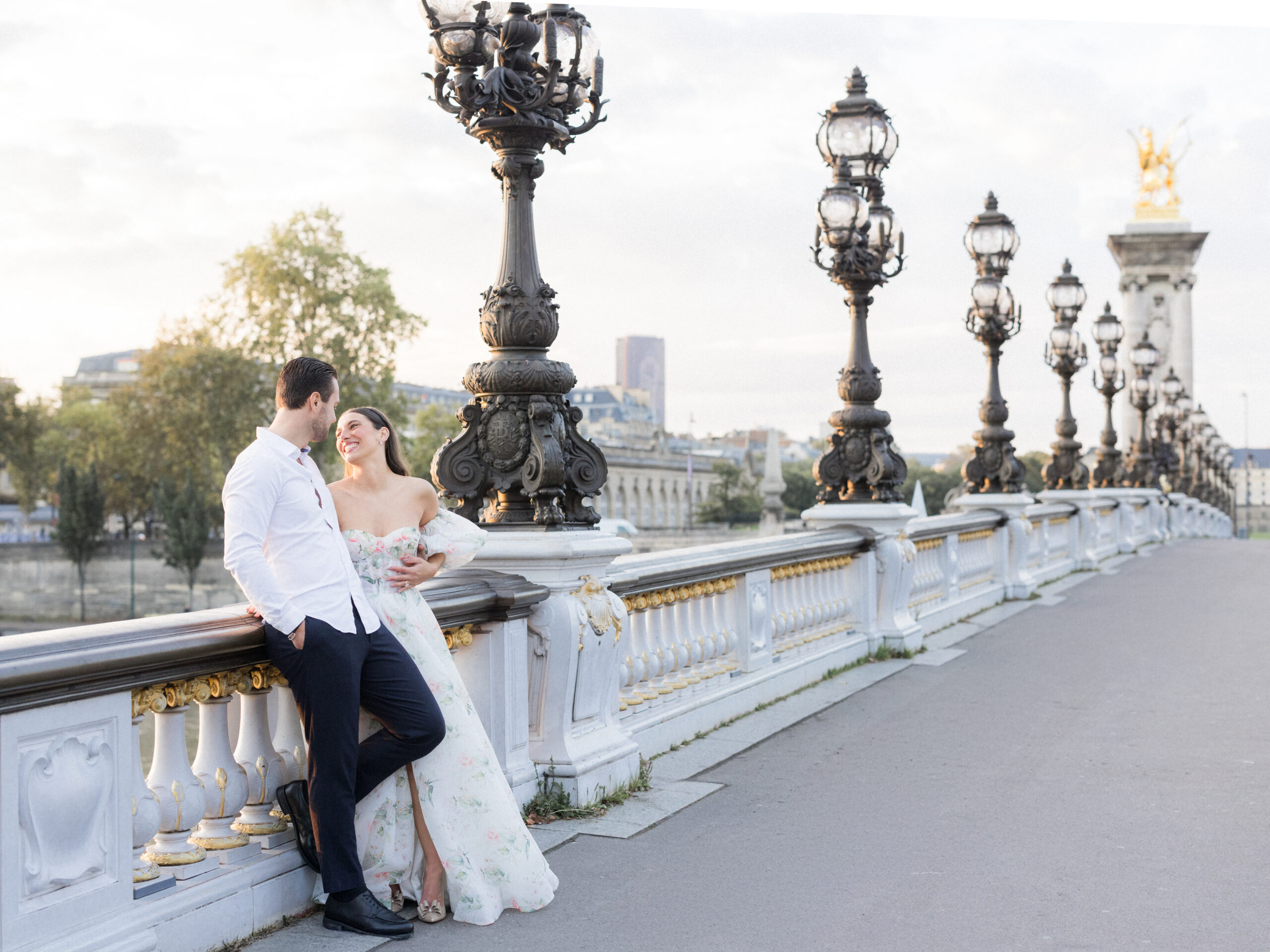 Sinaï laughing as Abraham holds her on the bridge, with golden light behind them Love Tree Studios.