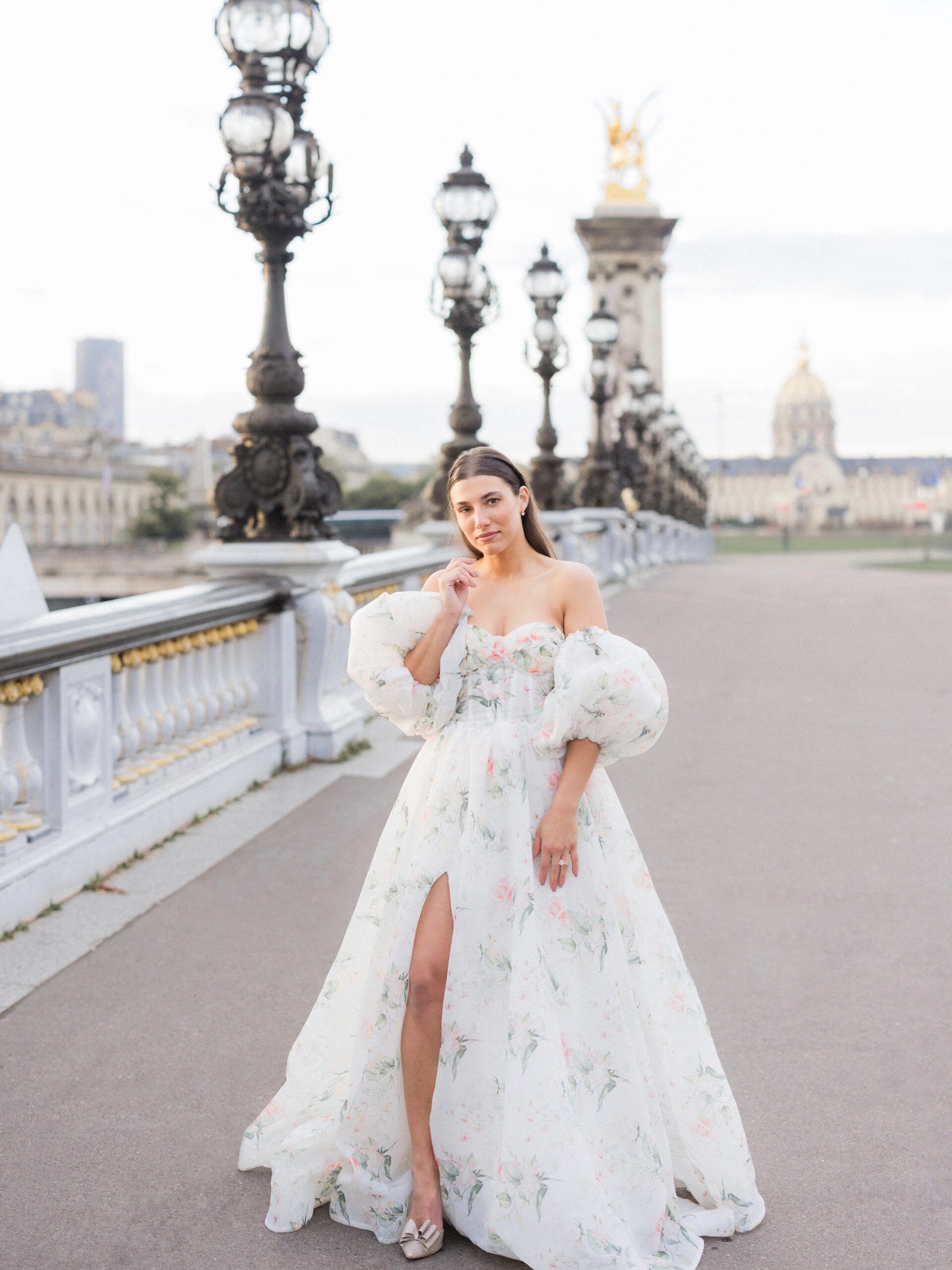 Portrait of Sinaï framed by the intricate lampposts of Pont Alexandre III Bridge during their Paris portrait session.