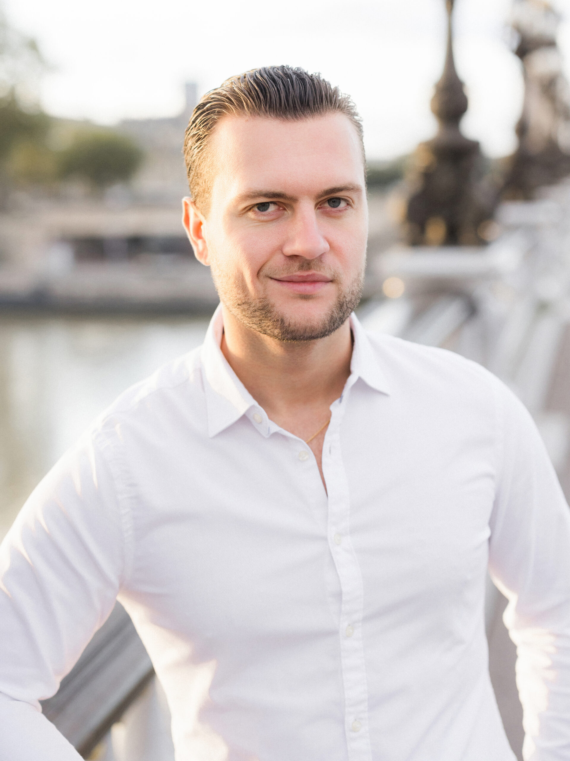 Abraham looking thoughtfully at the camera on Pont Alexandre III Bridge, with the city of Paris in the background Love Tree Studios.