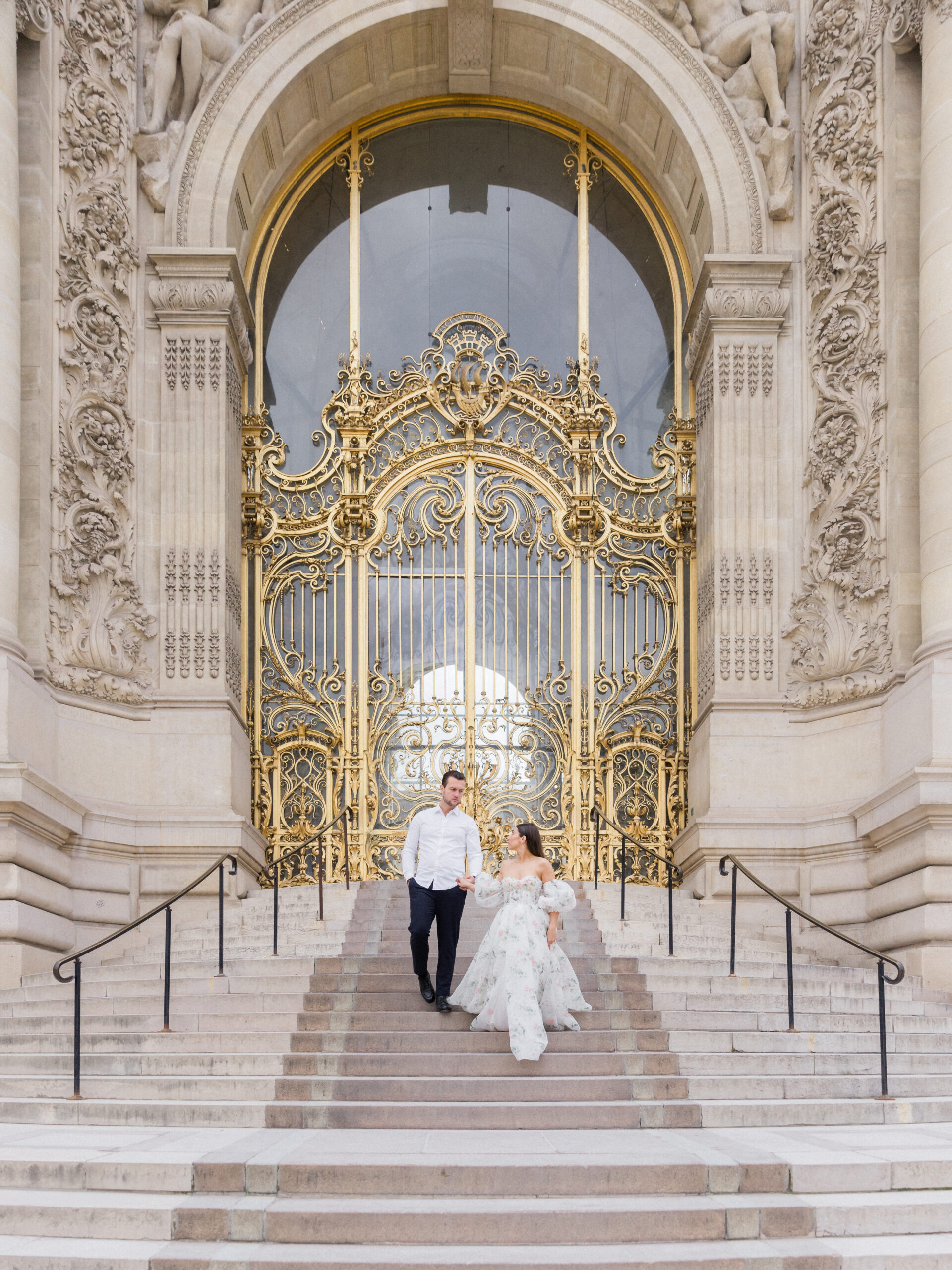 Wide shot of Sinaï and Abraham standing at the center of the golden gate, looking into each other’s eyes Love Tree Studios.