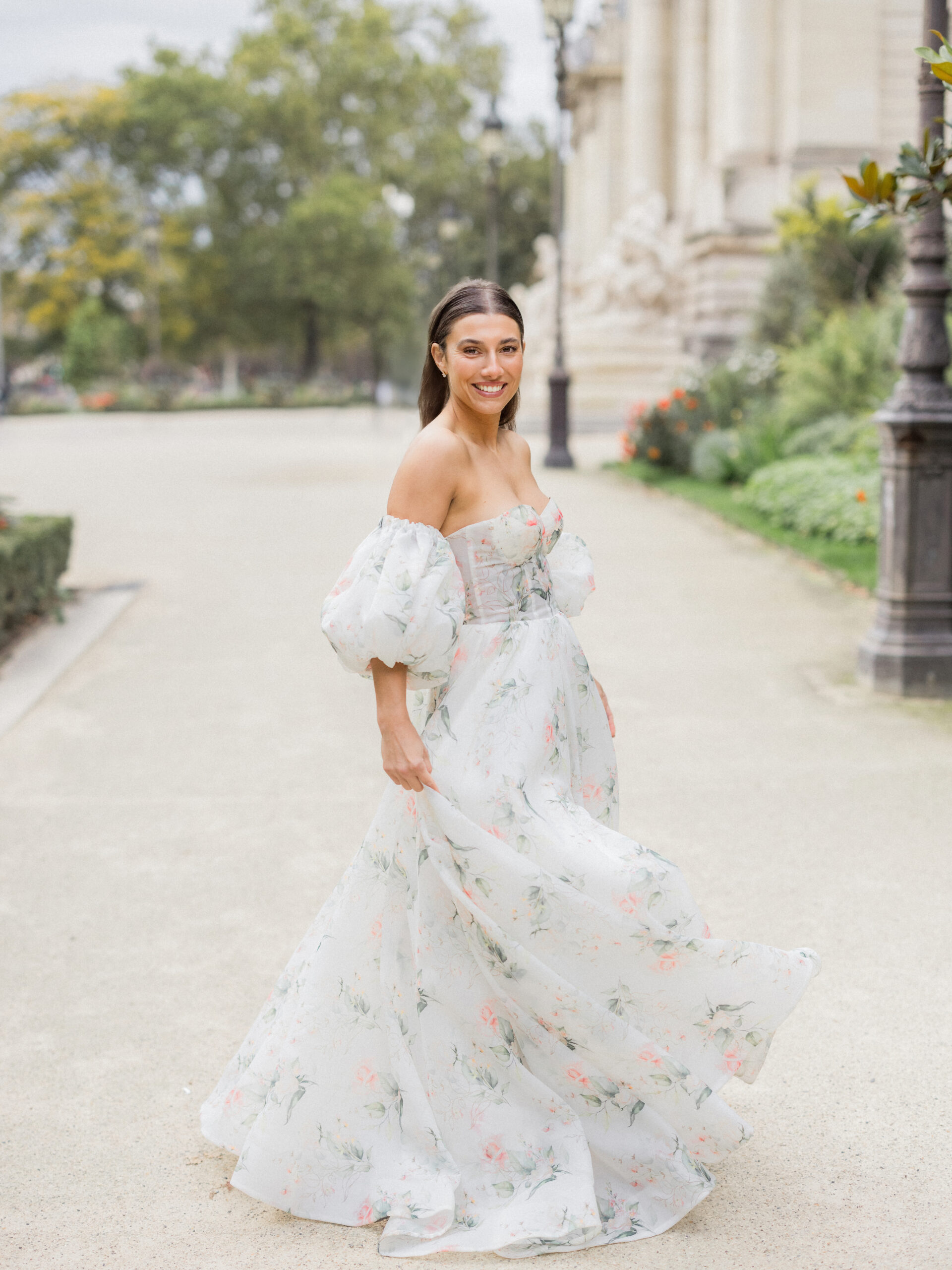 Sinaï standing by the grand entrance of La Petite Palace, surrounded by elegant architecture during her Paris portrait session Love Tree Studios.