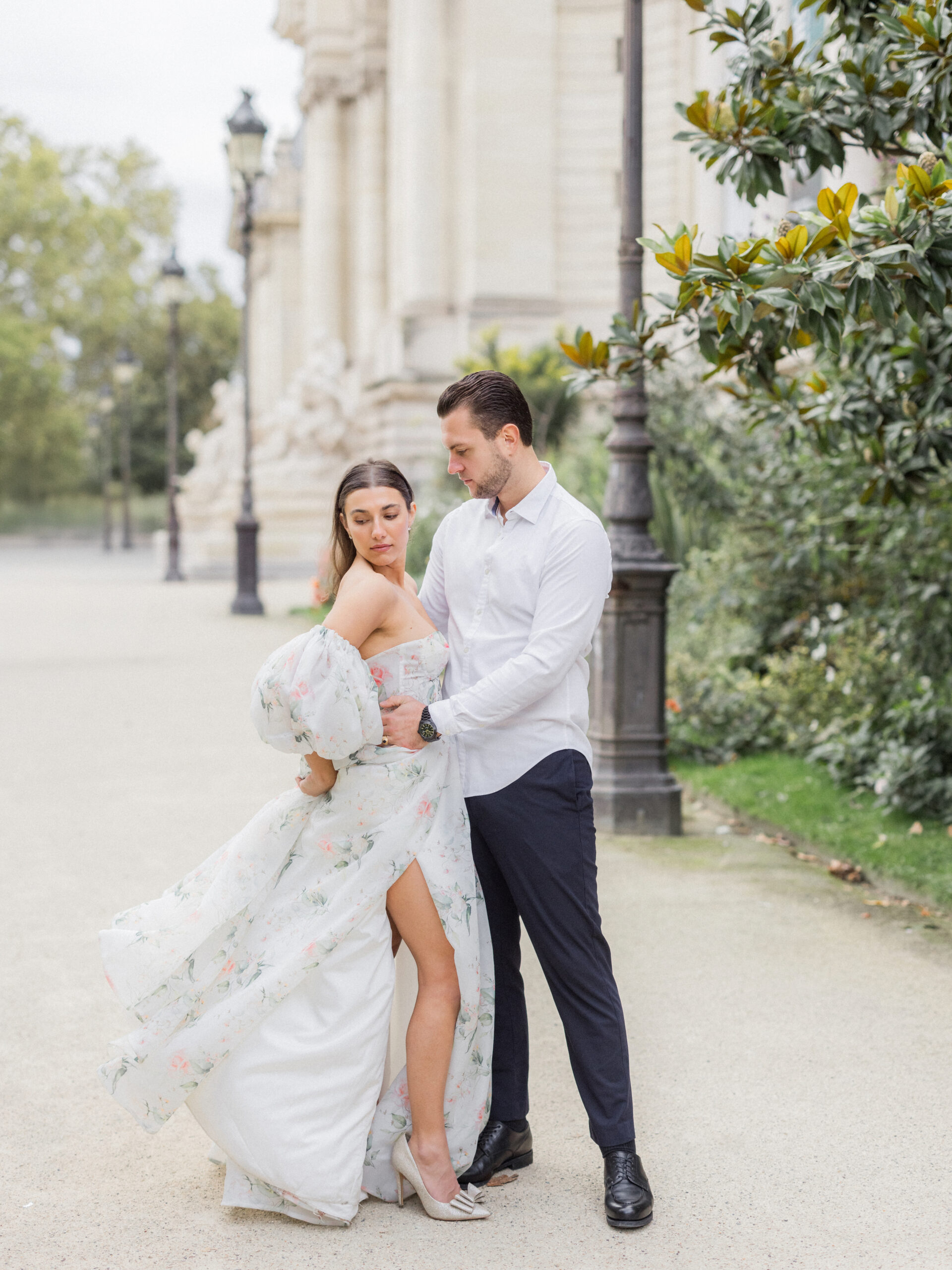 Sinaï’s floral gown flowing as she stands next to Abraham near the La Petite Palace entrance Love Tree Studios.