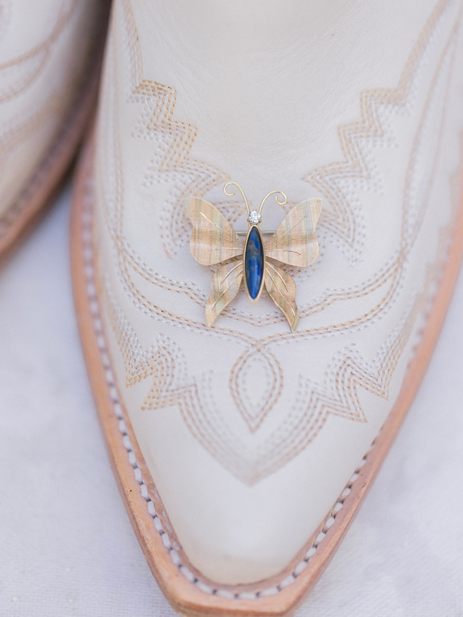 Detail shot of white cowboy boots and bridal accessories for a chic Western Missouri wedding by Love Tree Studios.