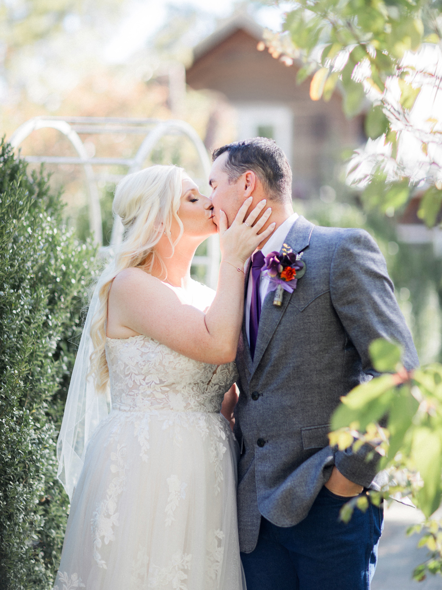 Bride and groom sharing a romantic moment with rustic barn backdrop at a chic Western Missouri wedding, photographed by Love Tree Studios.