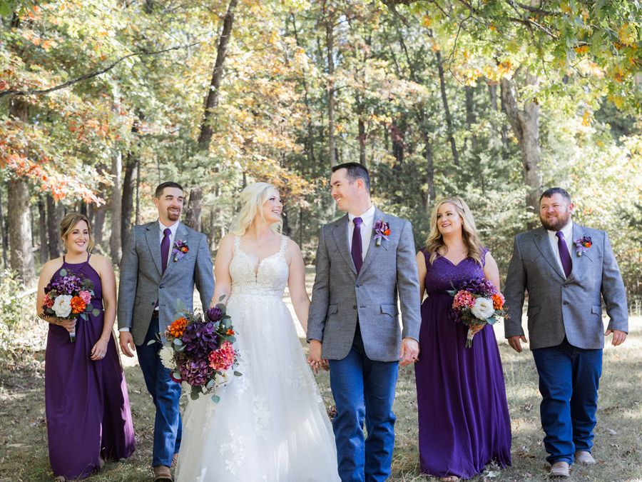 Bridal party in deep purple dresses and gray blazers, perfectly matching the chic Western Missouri wedding theme, captured by Love Tree Studios.