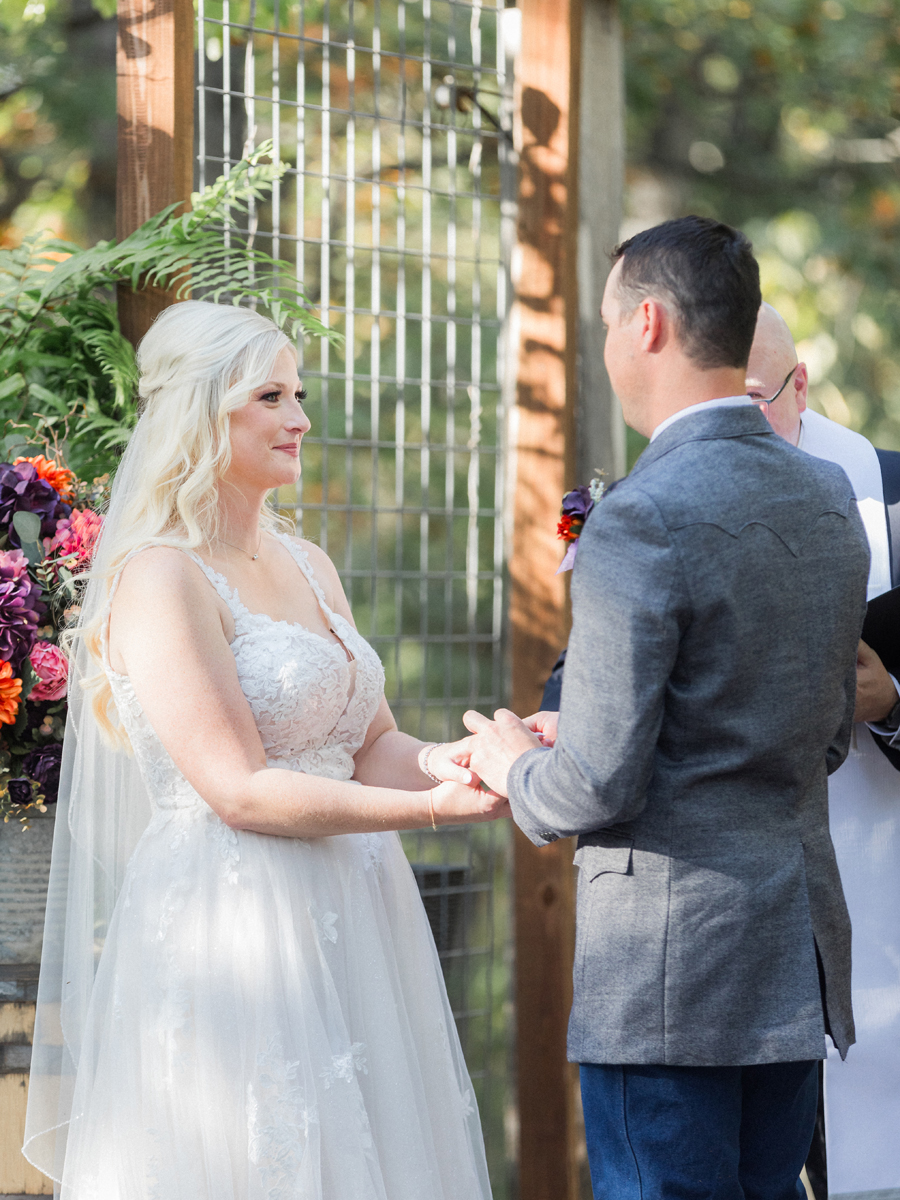 Couple exchanging vows at their chic Western Missouri wedding at Alpine Park and Gardens, captured by Love Tree Studios.