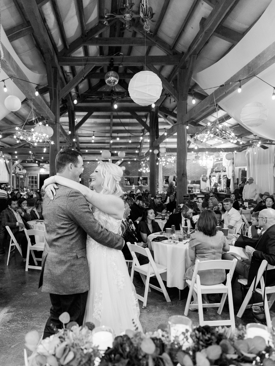 Bride and groom's first dance under string lights during their chic Western Missouri wedding, photographed by Love Tree Studios.