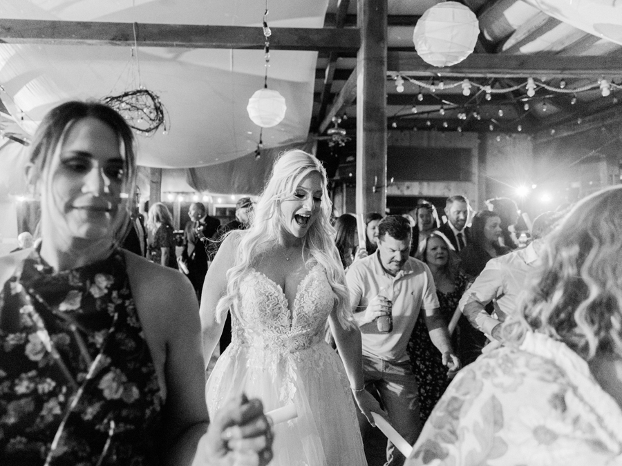 Guests dancing under string lights during the lively reception at Taylor and Troy’s chic Western Missouri wedding.