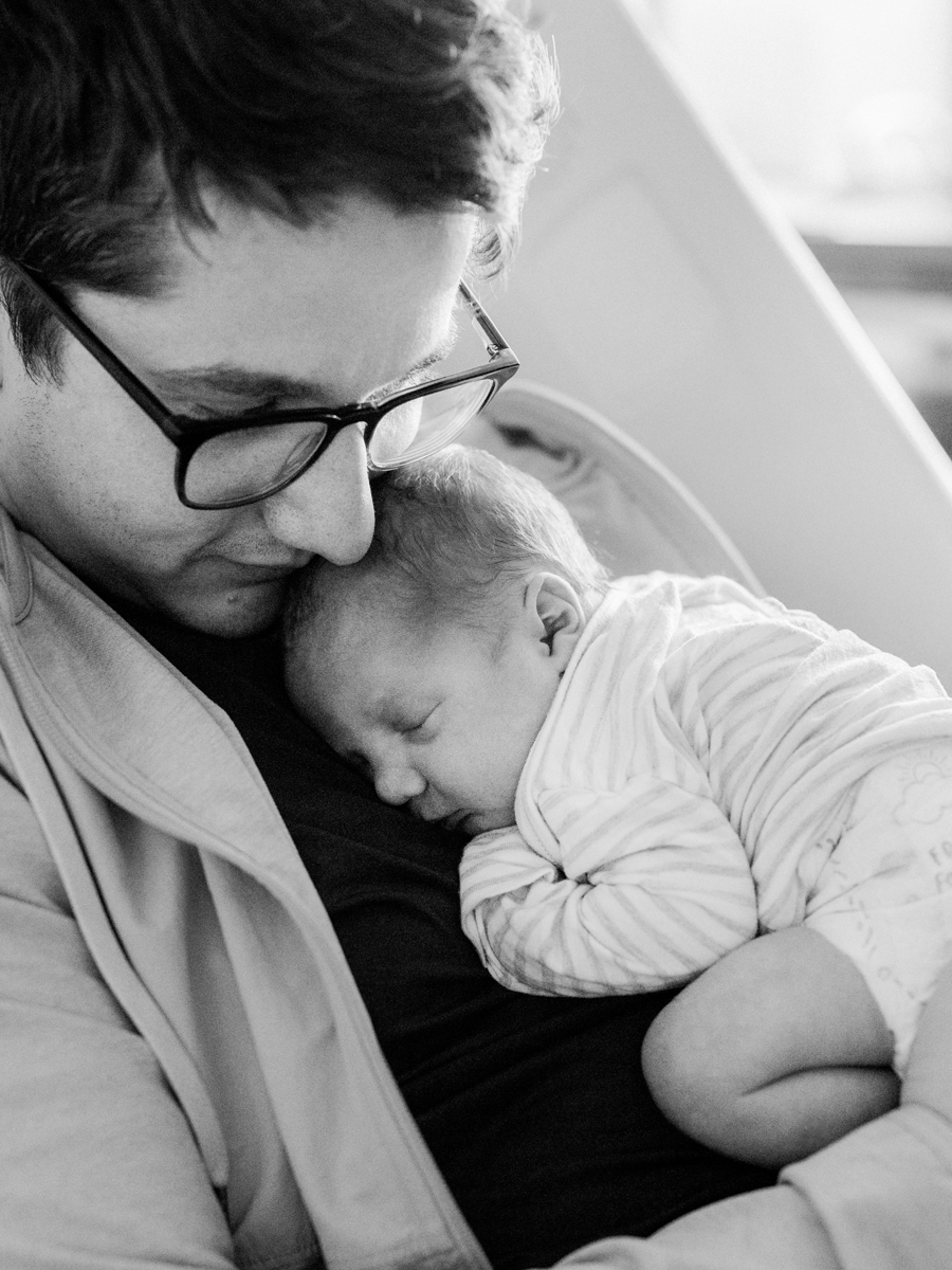 Close-up shot of a newborn’s face during a Fresh 48 session, captured in black and white with soft light.