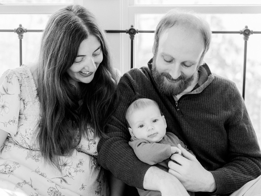 Parents cuddling baby Corbin Wesley on the bed in their Columbia, MO home during a newborn photography session.